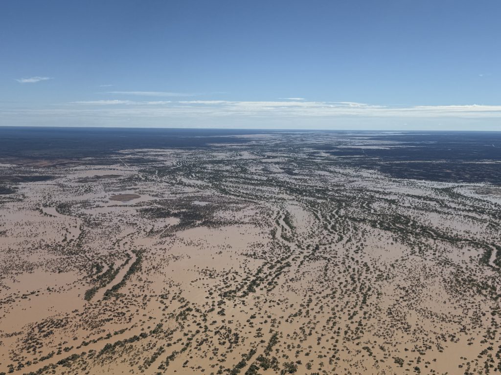 From the air, kilometres of floodwater inundate trees, channels and property across Western Queensland.