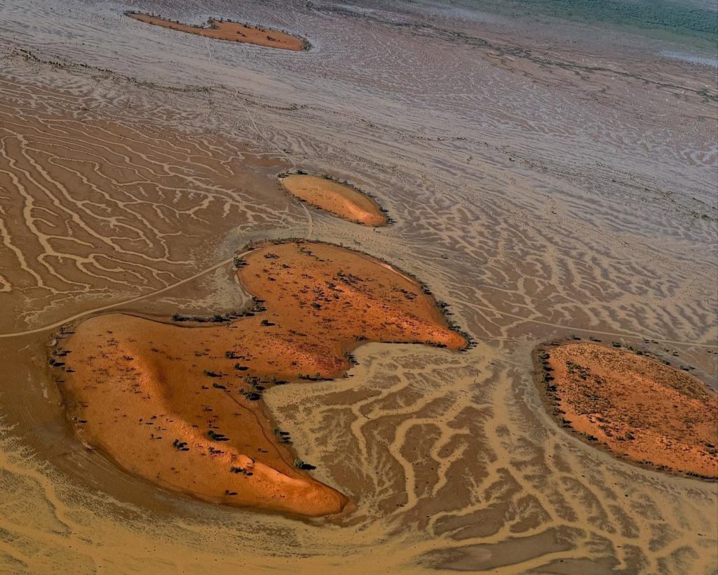 Receding floodwaters revealed braided channels along the sunburnt clay pans of Windorah's floodplains.